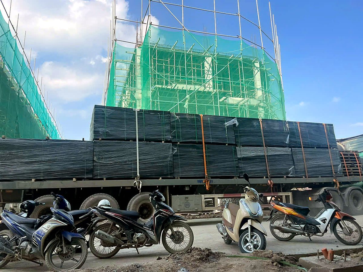 Kiện ván trên xe được giao tới chân công trình